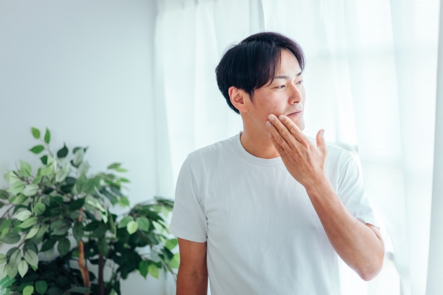 頬を触る男性